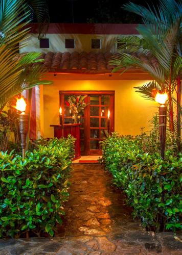 a house with a pathway leading to the front door at Hotel Iguana Verde in Orotina