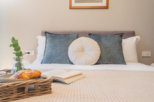 a bed with a book and a basket of food on it at V Suite on Lake Como By Rent All Como in Como