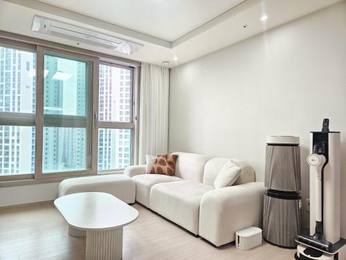 a living room with a white couch and a table at Oceanstay The Songdo Penthouse in Incheon