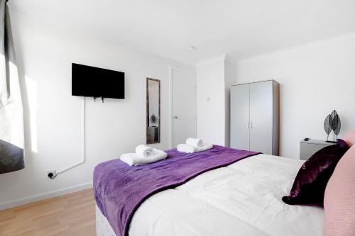 a white bedroom with a large bed with two towels at NEW! 4BR in Stafford Place in Peterlee