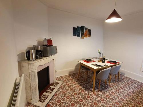 comedor con mesa y chimenea en Le Compiégnois, en Compiègne