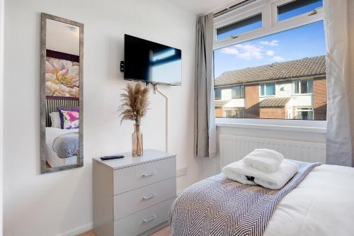 a bedroom with a bed and a mirror and a window at NEW! 4BR in Stafford Place in Peterlee