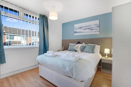 a bedroom with a bed with blue walls and a window at NEW! 4BR in Stafford Place in Peterlee