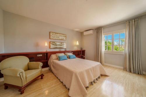 a bedroom with a bed and a chair and a window at C221 CAN MANDOL ETV6207 by Mallorca Villa Selection in Inca