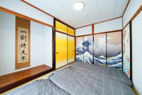 a bed in a room with large windows at oyadoya nagoya nakamura 地下鉄中村公園駅徒歩7分 最大8名 駐車場有り in Nagoya