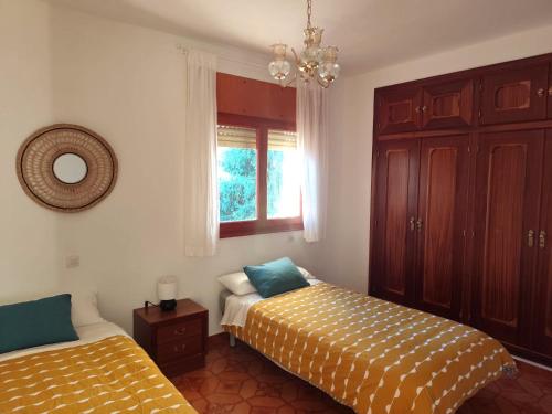 a bedroom with two beds and a window at La Campanera in Las Navas del Marqués