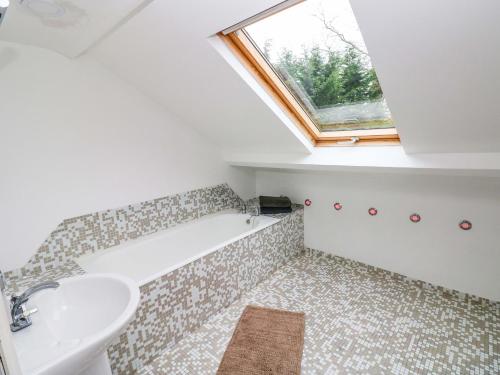 un baño con lavabo y bañera en Norchard Farm House, en Tenby