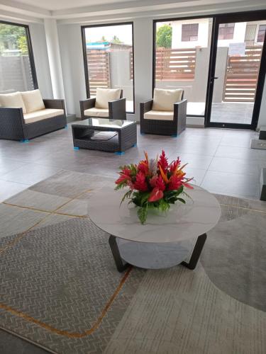 a lobby with couches and a table with flowers on it at Hibiscus Suites And Residences in Nadi