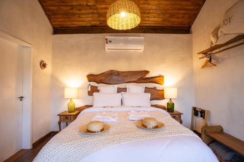 a bedroom with a bed with two hats on it at Chalé Pétala - Vila Monte Cunha in Cunha