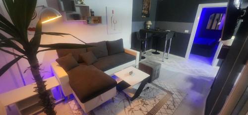 a living room with a couch and a palm tree at Iva's Apartment in Gostivar