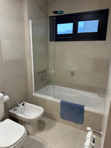 Un baño con inodoro, bañera y lavabo. en ETOCS - Departamento con piscina - Excelente ubicación - Opcional cochera, en Bahía Blanca