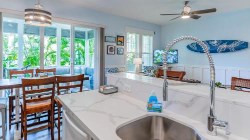 a kitchen with a sink and a table with chairs at Coconut Plantation 1214-2 Aloha Lagoons in Kapolei