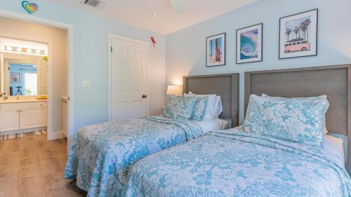 a bedroom with two beds with blue and white sheets at Coconut Plantation 1214-2 Aloha Lagoons in Kapolei