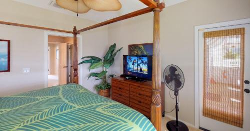a bedroom with a bed and a flat screen tv at Coconut Plantation 1194-3 in Kapolei