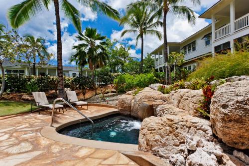 a pool with a waterfall and two chairs in a yard at Coconut Plantation 1194-3 in Kapolei