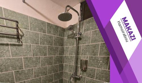 a shower with a shower head in a bathroom at MAKAZI Hamoirabou in Tsingoni