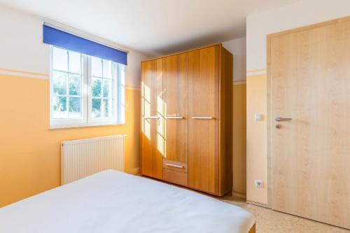 a bedroom with a bed and a wooden cabinet at Ferienwohnung Johanna OG in Wohlenberg