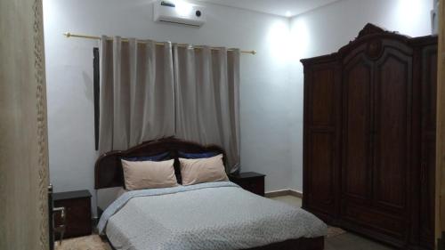 a bedroom with a bed with a wooden headboard at Villa isouktan in Sbiti