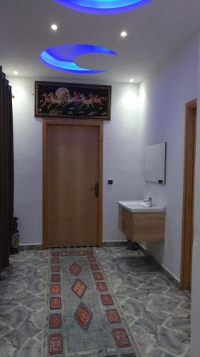 a room with a door and a blue ceiling at Villa isouktan in Sbiti
