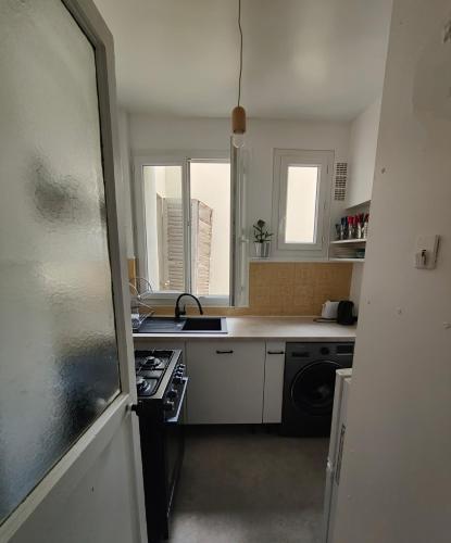 une petite cuisine avec un évier et une cuisinière dans l'établissement La Fourche, à Paris
