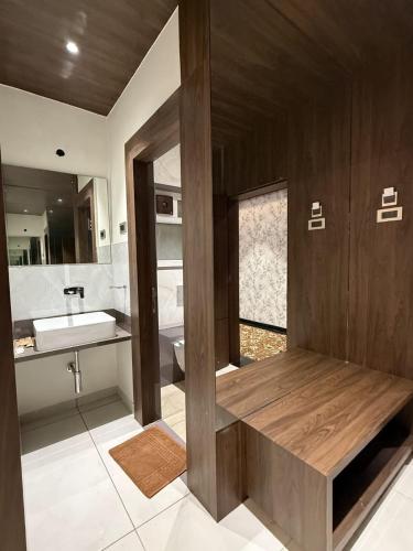 a bathroom with a sink and a wooden bench at Golden Heritage Dapoli in Dapoli