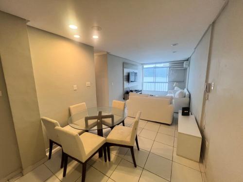a dining room and living room with a table and chairs at apartamento sao vicente vista mar pe na areia in São Vicente