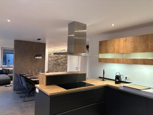 a kitchen with black cabinets and a dining room at Hyronimus House in Amblève