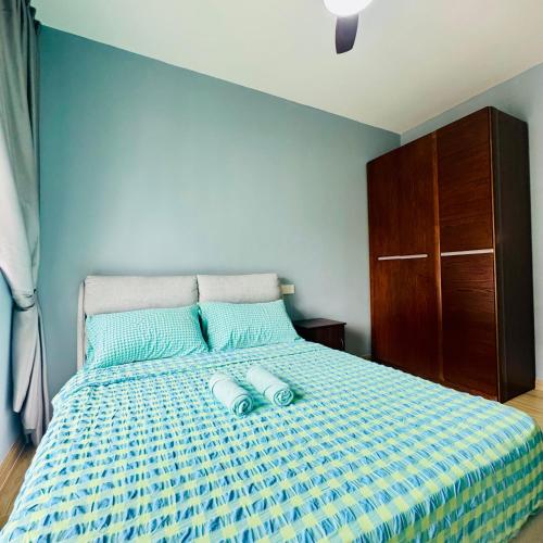 Schlafzimmer mit einem großen Bett mit blauer Tagesdecke in der Unterkunft Regalia 2B1R 6pax Condo Forest City GB H-3003 in Gelang Patah