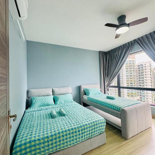 ein Schlafzimmer mit zwei Betten und einem Deckenventilator in der Unterkunft Regalia 2B1R 6pax Condo Forest City GB H-3003 in Gelang Patah