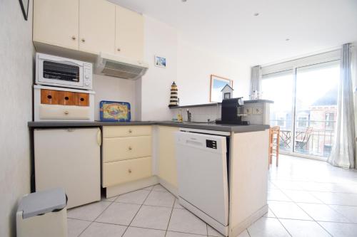 une cuisine avec un réfrigérateur et un lave-vaisselle dans l'établissement Appt 2 pièces confort 3 pers au pied de la plage vacances sans voiture, à Dinard