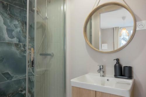 une salle de bain avec un lavabo et une douche avec un miroir dans l'établissement Appartement centre historique, à Orléans