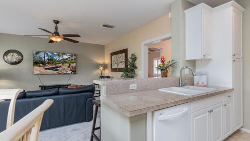 a kitchen and living room with a blue couch at Coconut Plantation 1192-4 in Kapolei