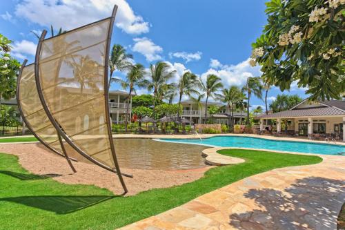 a pool at a resort with a sign in the grass at Coconut Plantation 1192-4 in Kapolei