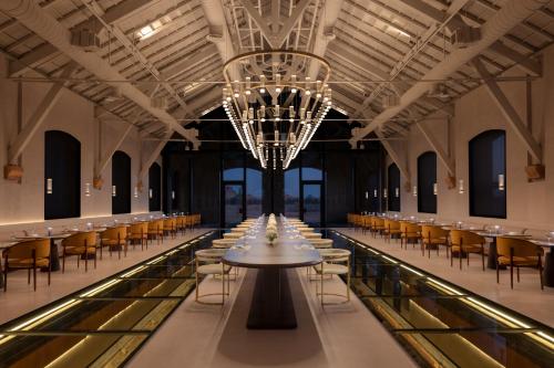 a large hall with tables and chairs and a chandelier at The Chedi Hegra, AlUla in AlUla