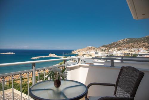 a balcony with a table and chairs and the ocean at Hotel Astron Princess in Karpathos Town