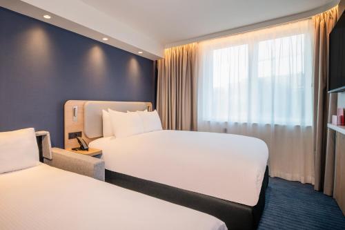 a hotel room with two beds and a window at Holiday Inn Express & Suites Ghent by IHG in Ghent