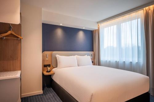 a hotel room with a bed and a window at Holiday Inn Express & Suites Ghent by IHG in Ghent