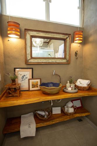 a bathroom with a wooden shelf with a mirror at Chalé Girassol - Vila Monte Cunha in Cunha