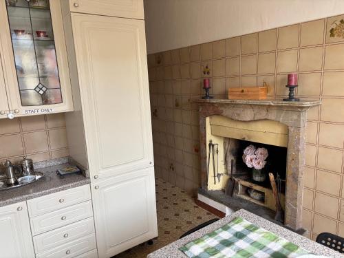 a kitchen with a fireplace in the corner of a room at Casa Caterina in Intra