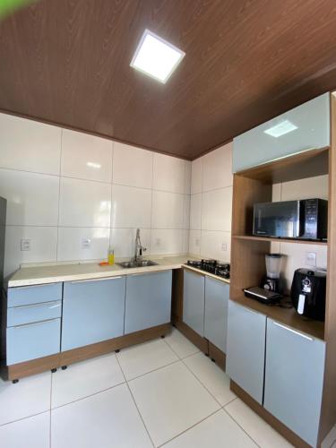 a kitchen with white cabinets and a sink at Pousada do Nativo in Fernando de Noronha