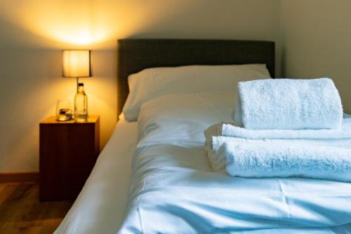 a bed with white sheets and towels on it at Hotel Restaurant Simplon - Self Check-in in Brig