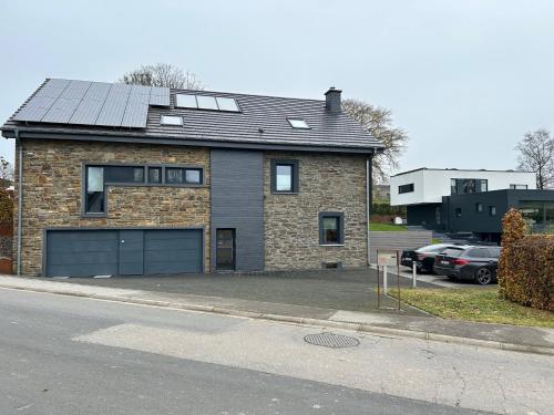 a brick house with a garage in a parking lot at Hyronimus House in Amblève