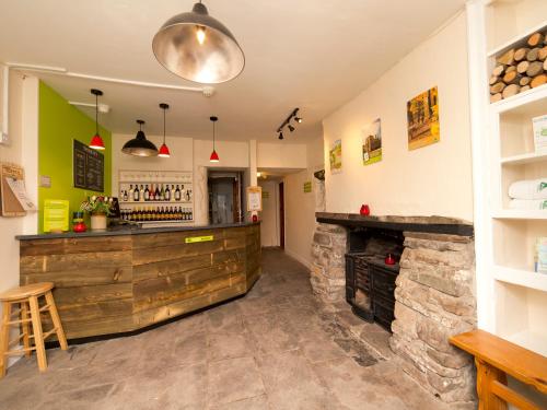 a bar in a restaurant with a stone fireplace at YHA Brecon Beacons in Brecon