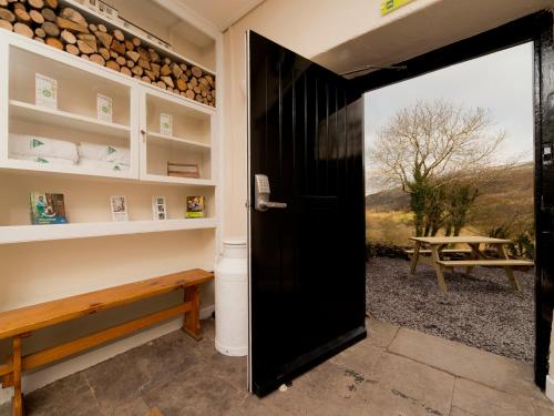 a door in a room with a bench and a table at YHA Brecon Beacons in Brecon