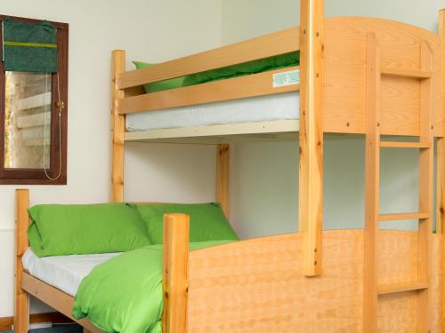 a bunk bed with a couch next to a bunk bed with a ladder at YHA Brecon Beacons in Brecon