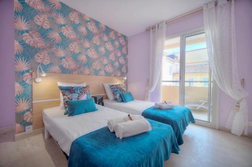 - 2 lits dans une chambre avec papier peint bleu et rouge dans l'établissement 3 PIECES en DUPLEX , CENTRAL A2B103, à Cannes