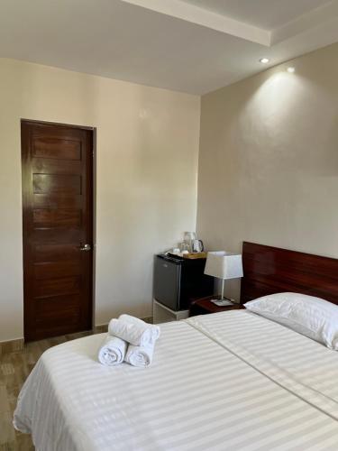 a bedroom with a bed with two towels on it at Maykenn Beach in Bantayan Island