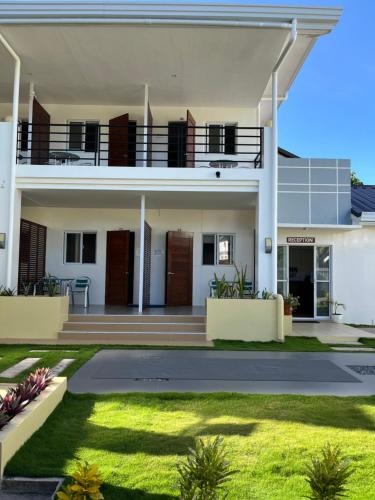 a large white house with a lawn in front of it at Maykenn Beach in Bantayan Island