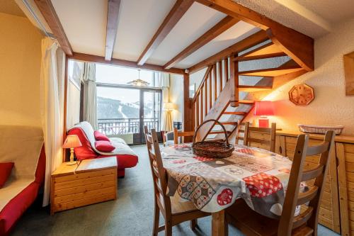 une salle à manger avec une table et un escalier dans l'établissement Bel appartement au pied des pistes, à Notre-Dame-de-Bellecombe