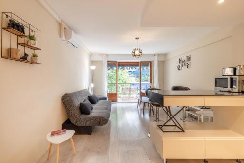 un salon avec un canapé, une table et une cuisine dans l'établissement Yank's centre Juan Les Pins 5 min des plages, à Juan-les-Pins